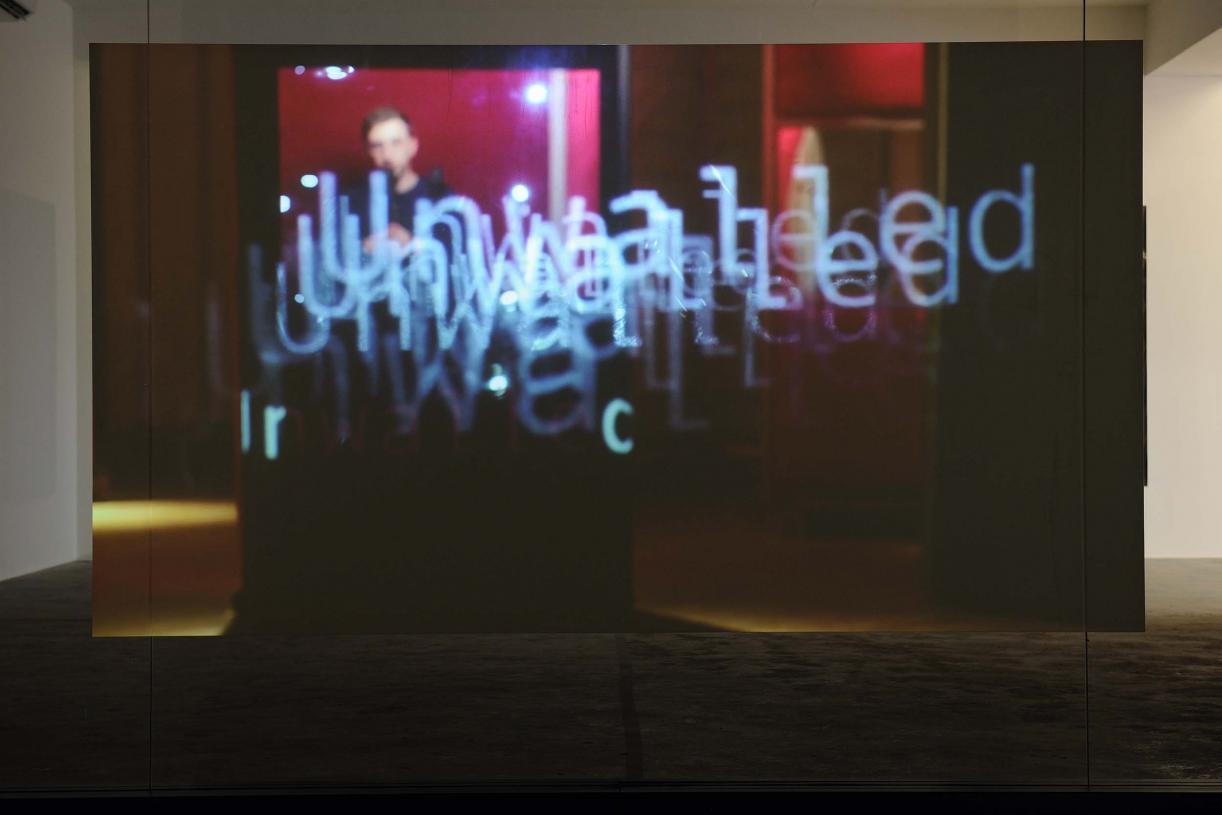 Walled Unwalled, 2018, Single-channel video, color, sound, Installation, with metal structure, glass & foil, 20 mins, Ed. 6 + 2 AP, Wall design in collaboration with Müller Aprahamian