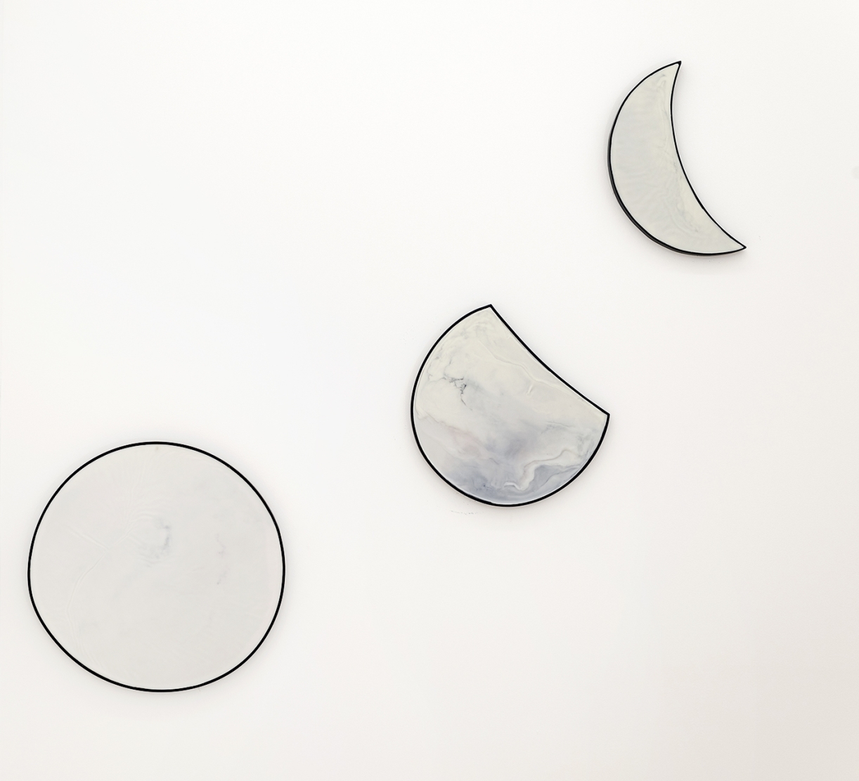 Moon(s), 2024, Beeswax, oil paint on iron and wood, Ø 60 cm (full moon), 45 × 40 cm (waxing gibbous), 46 × 33 cm (waning crescent)