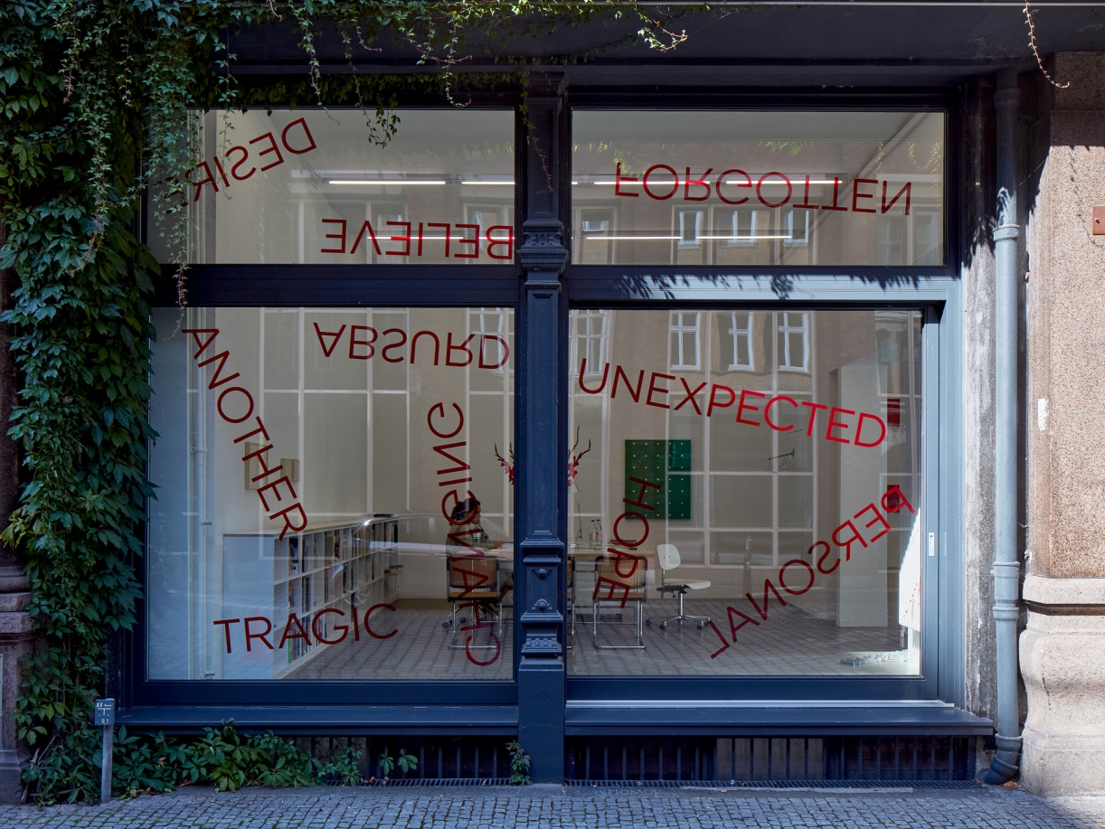 Untitled, 2024, 19 red foil words on window, Dimensions variable