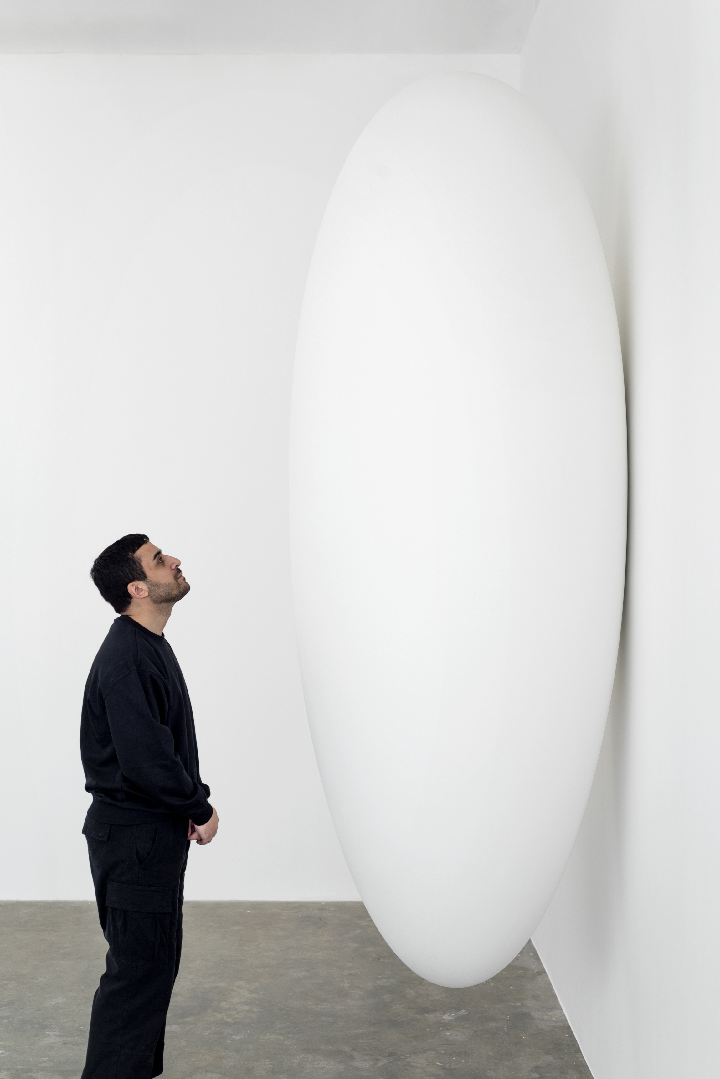 Tarik Kiswanson next to his sculpture "Nest" (2022, fiberglass and resin, edition 7 + 2 APs, 270 x 100 cm)
