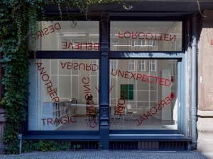 Untitled, 2024, 19 red foil words on window, Dimensions variable